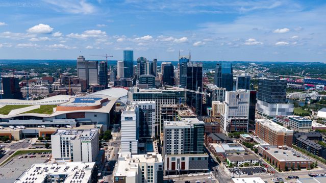 Aerial photo of Nashville skyline captured on a clear day with blue skies and modern skyscrapers.